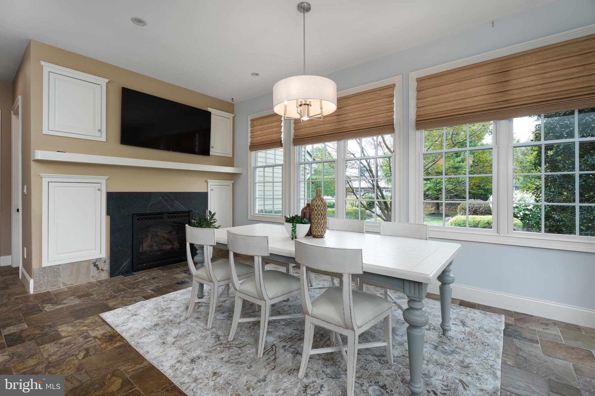 6997 Phillips Mill Road New Hope, PA 18938 - Photo 32 of 85 a dining room with furniture a fireplace and a floor to ceiling window