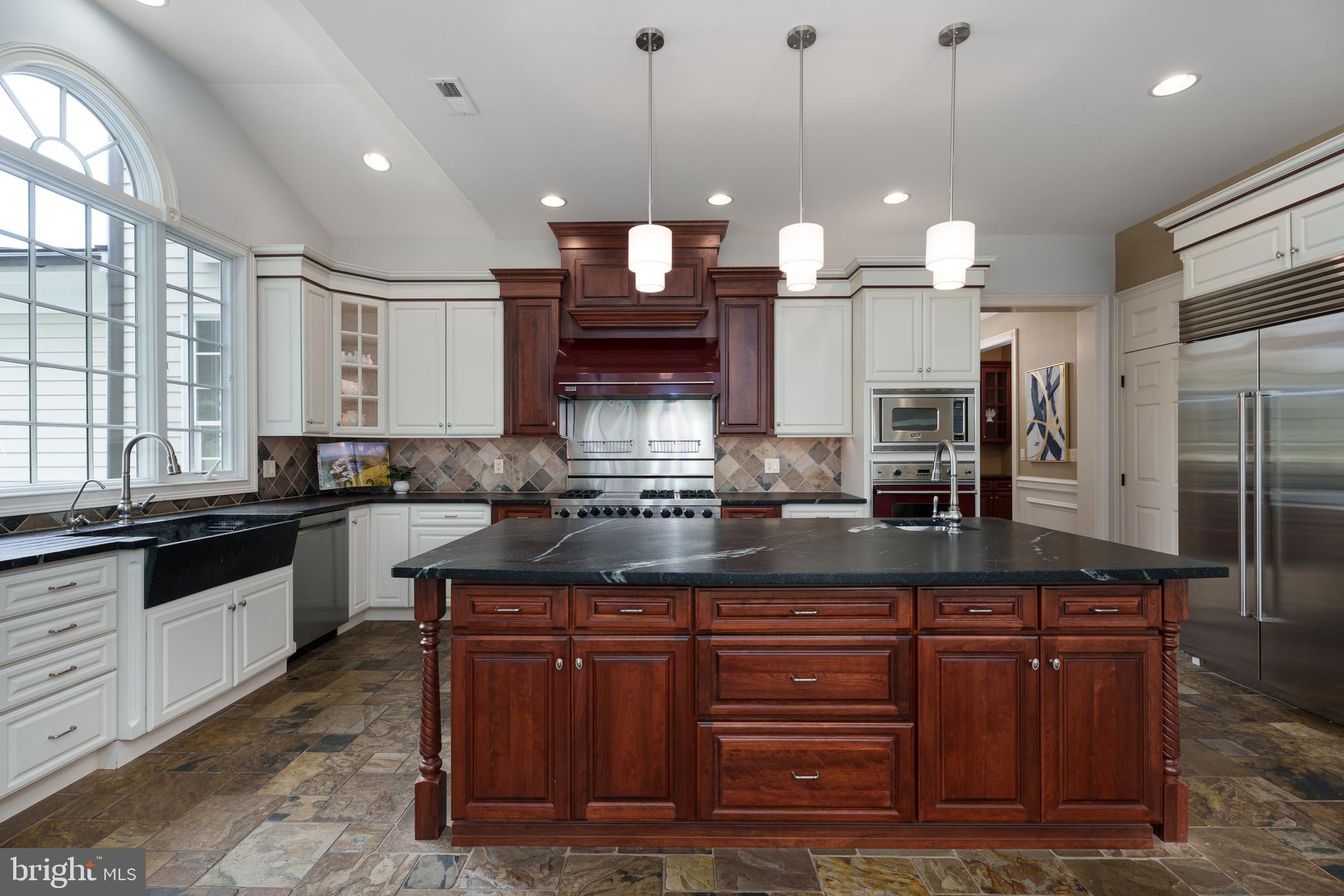 6997 Phillips Mill Road New Hope, PA 18938 - Photo 35 of 85 a kitchen with kitchen island granite countertop wooden cabinets and a wooden floor
