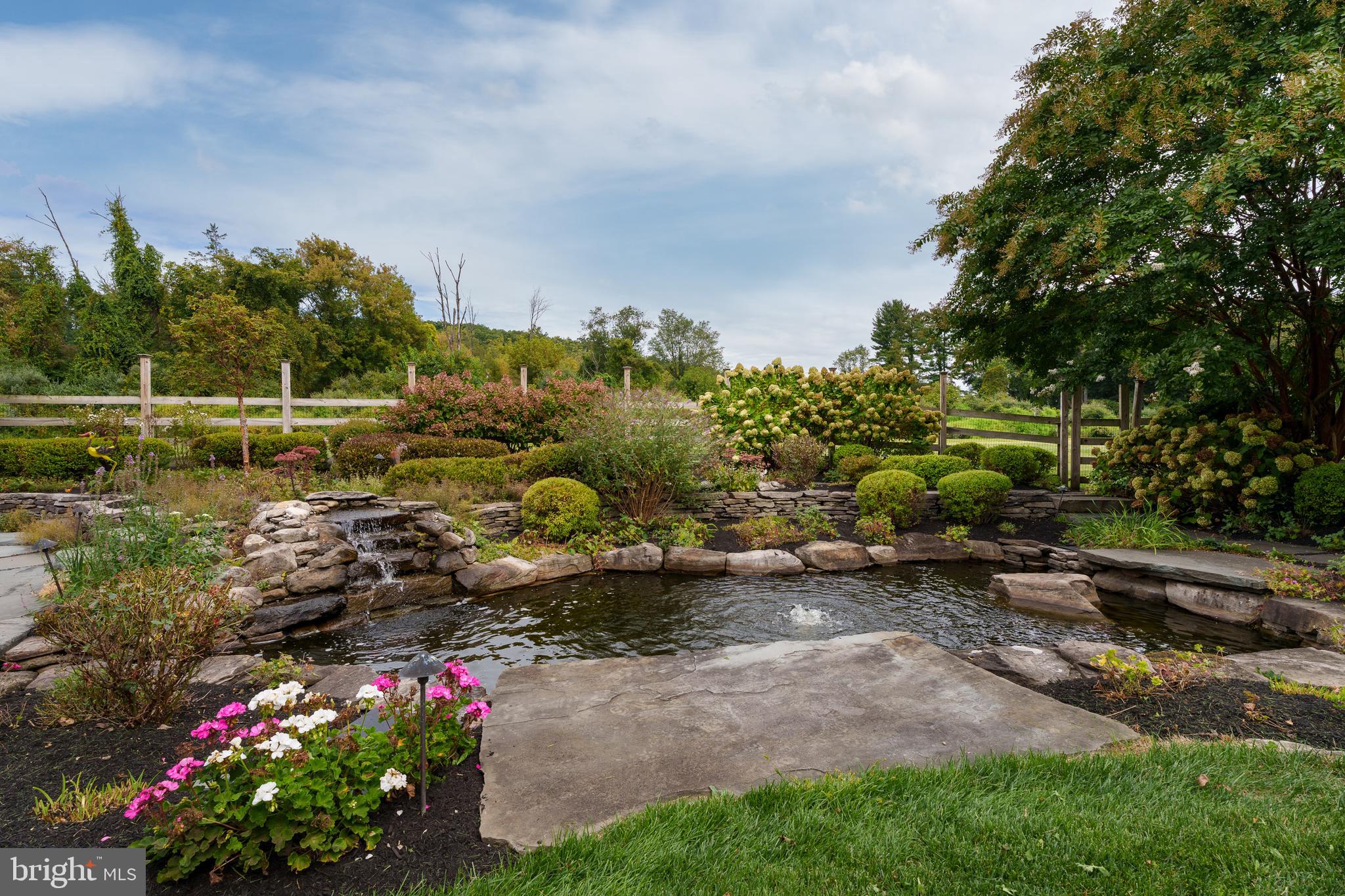 6997 Phillips Mill Road New Hope, PA 18938 - Photo 75 of 85 a view of a garden with a lot of flower plants and wooden fence