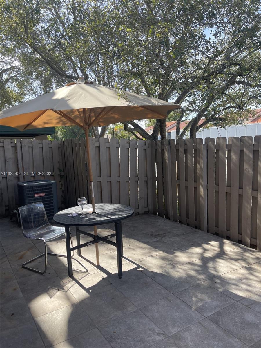 6606 Southwest 131st Path, Unit 1809A Miami, FL 33183 - Photo 1 of 14 a backyard of a house with table and chairs