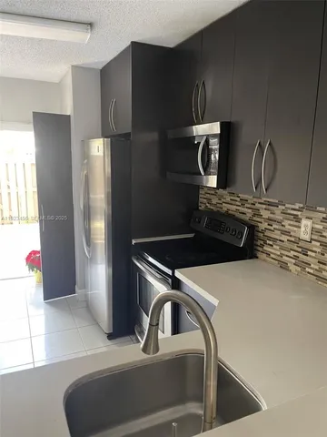 a kitchen with a refrigerator and a sink