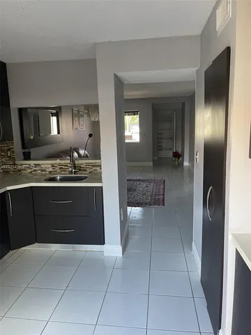 a kitchen with a refrigerator and a sink