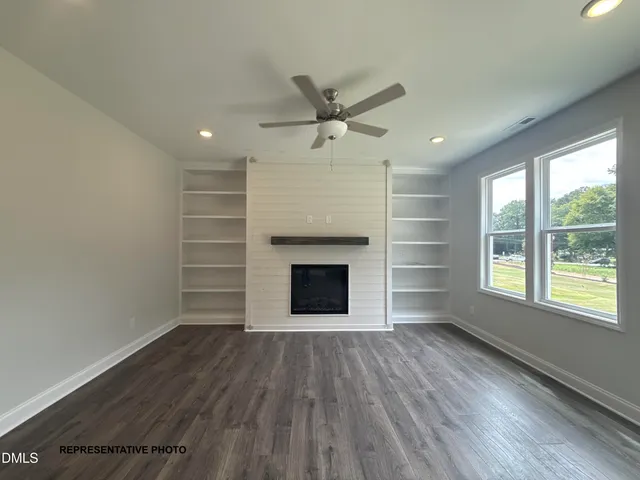 wooden floor fireplace and windows in an empty room