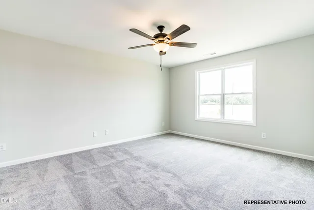 an empty room with a window and a ceiling fan