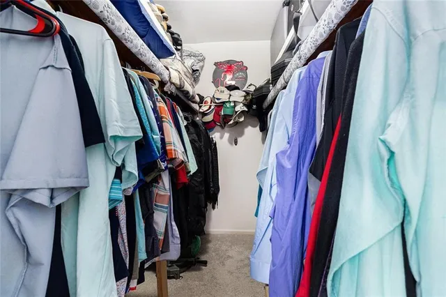 a view of walk in closet with clothes and shoes