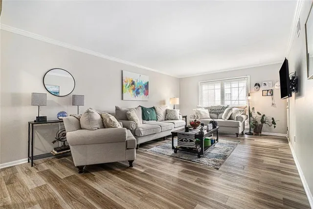 a living room with furniture a flat screen tv and a window