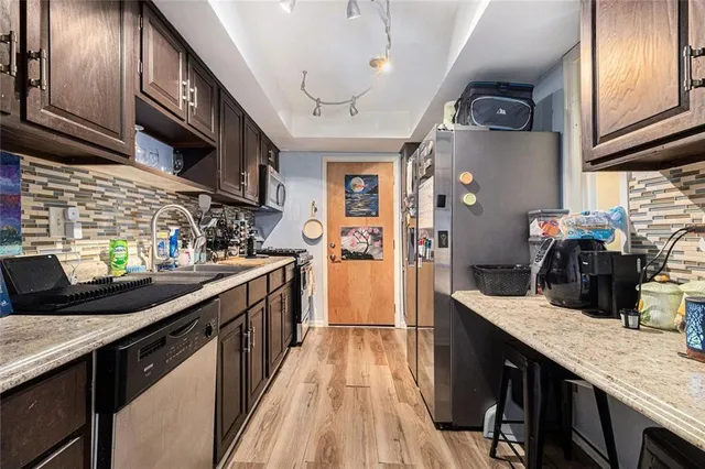 a kitchen with stainless steel appliances granite countertop a sink a stove and cabinets