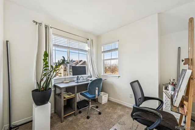 a view of a workspace with furniture and a window