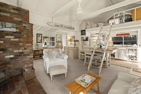 a living room with furniture a flat screen tv and kitchen view