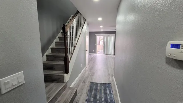a view of a hallway with wooden floor and entryway