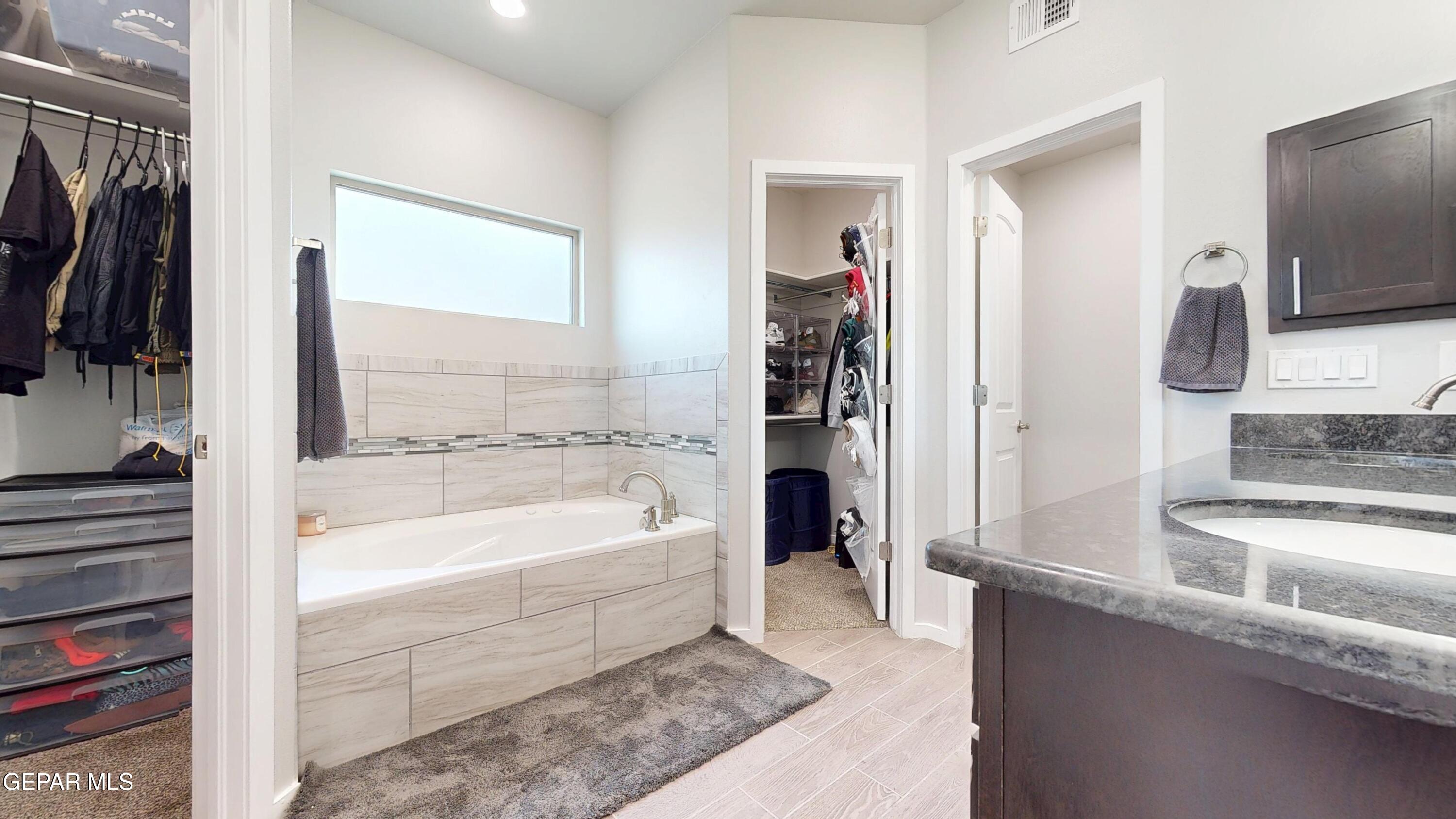 219 Notts Way El Paso, TX 79928 - Photo 22 of 35 a bathroom with a tub a sink and a large mirror