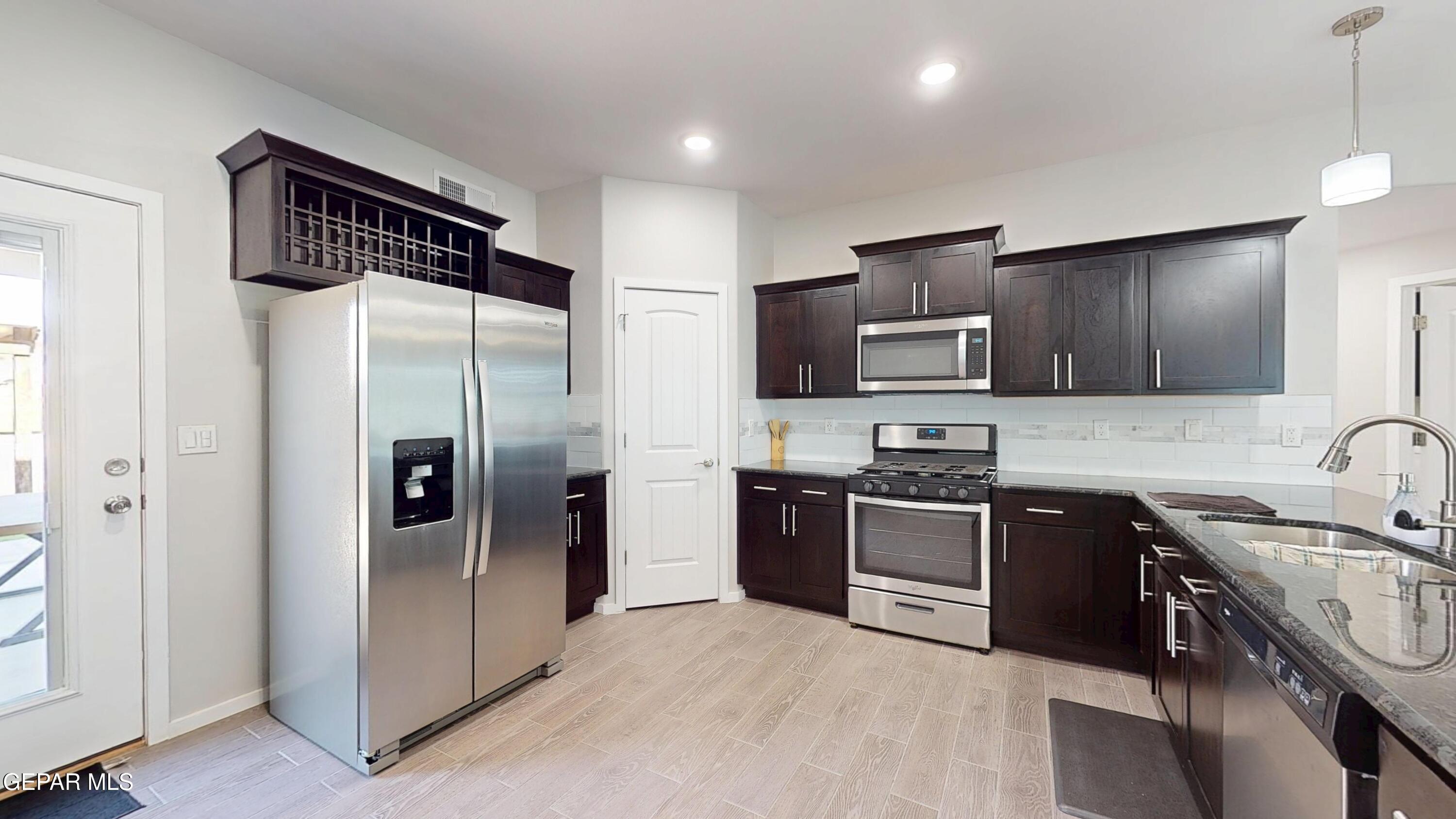 219 Notts Way El Paso, TX 79928 - Photo 10 of 35 a kitchen with stainless steel appliances granite countertop a refrigerator stove and sink