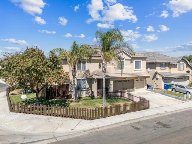 a front view of a house with a garden and trees