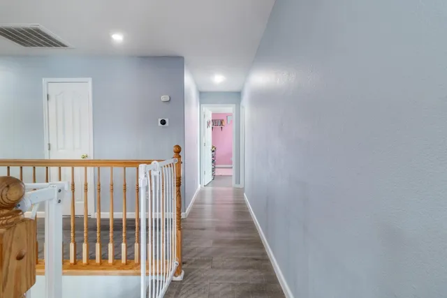 a view of a hallway with wooden floor