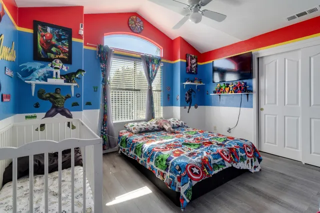 a bedroom with a bed a window and dresser