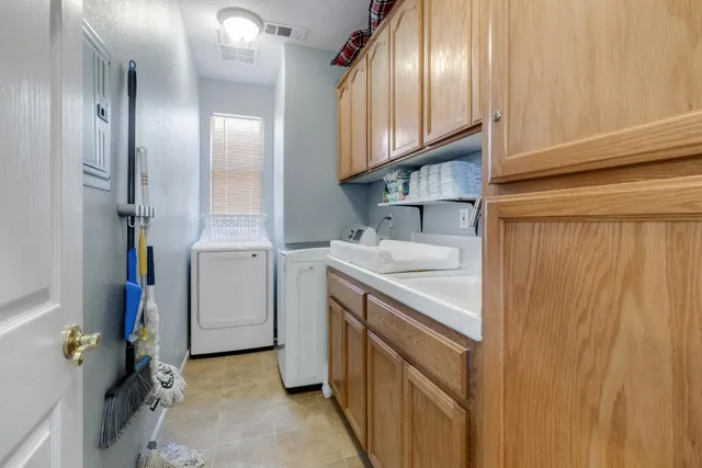 a utility room with cabinets washer and dryer