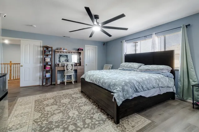 a spacious bedroom with a bed and a ceiling fan