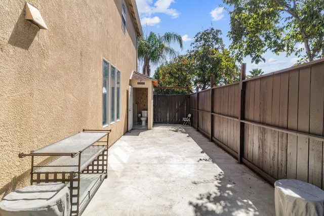 a view of backyard with wooden fence and large trees
