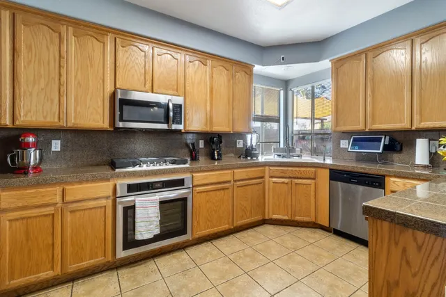 a kitchen with granite countertop cabinets stainless steel appliances a sink and a window