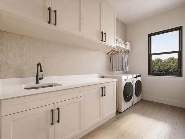 a utility room with sink dryer and washer