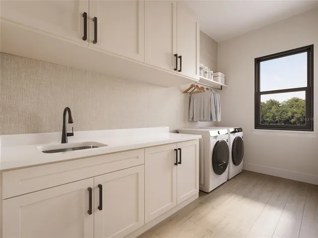 a utility room with sink dryer and washer