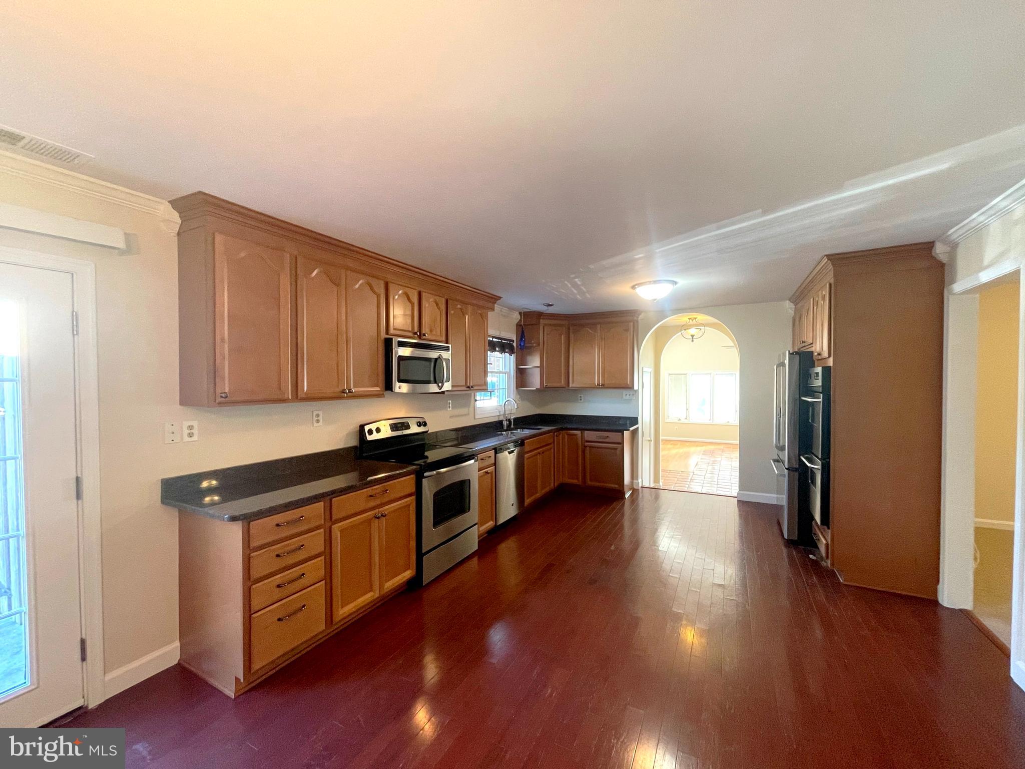 11717 Rivershore Drive Dunkirk, MD 20754 - Photo 8 of 49 a kitchen with stainless steel appliances kitchen island wooden cabinets and granite counter tops