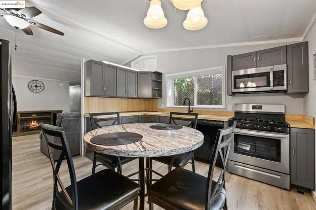 a kitchen with stainless steel appliances granite countertop a stove a sink and a microwave