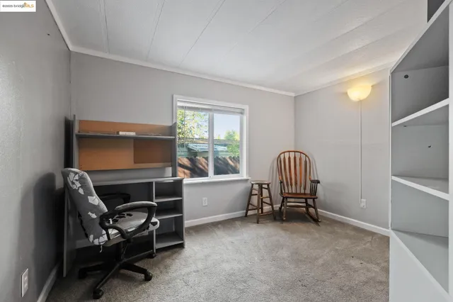 a bedroom with a chair and a window