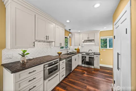 a kitchen with stainless steel appliances granite countertop a stove a sink and a refrigerator