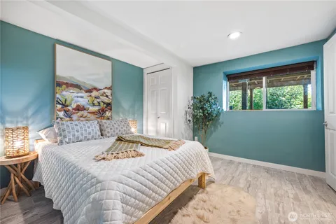 a bedroom with a bed and a painting on the wall