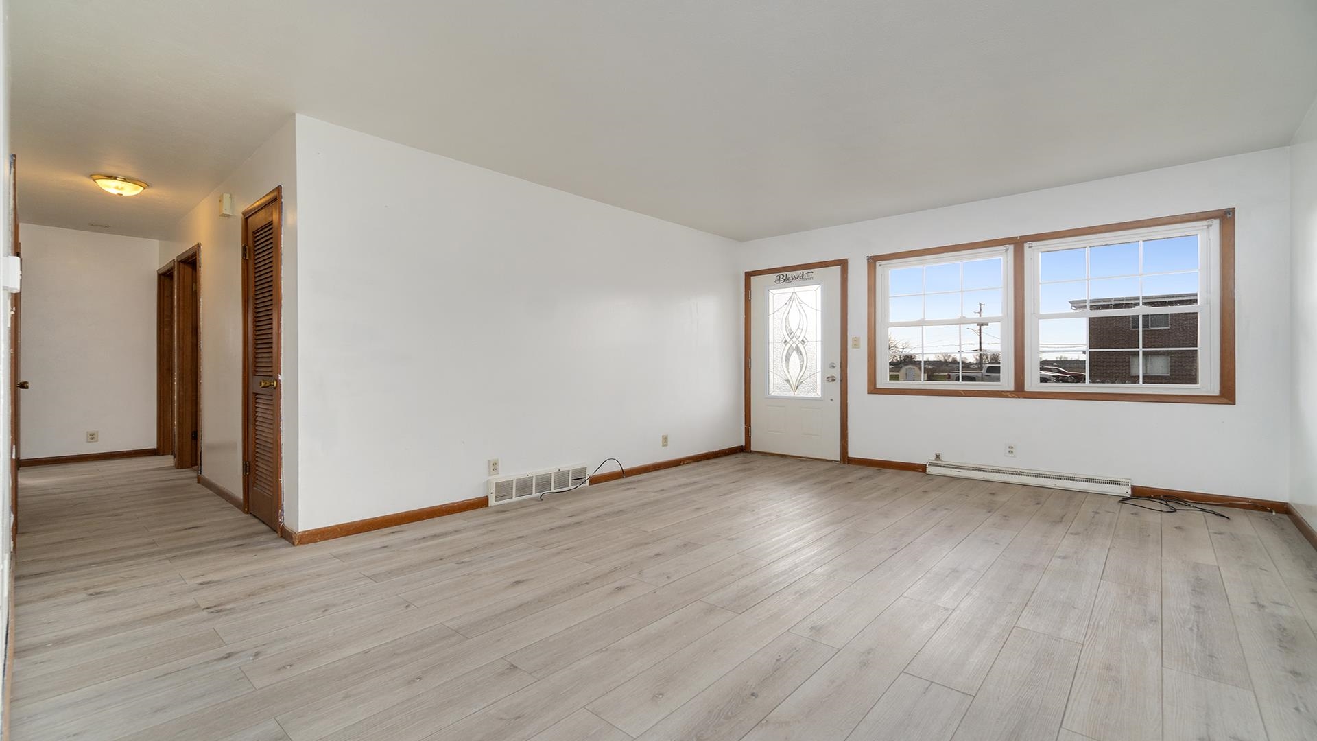 345 Irene Avenue Rochelle, IL 61068 - Photo 2 of 27 a view of an empty room with wooden floor and a window