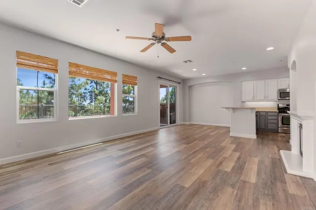 a view of empty room with kitchen and fireplace