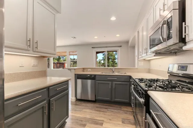 a kitchen with stainless steel appliances granite countertop a sink stove and cabinets