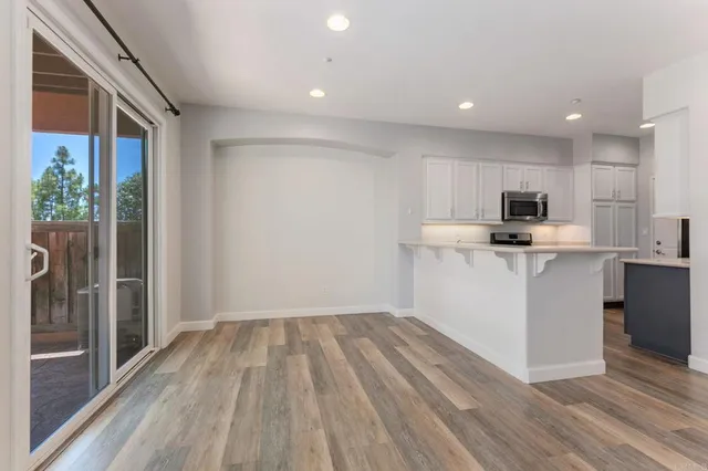a kitchen with granite countertop a sink stove and microwave