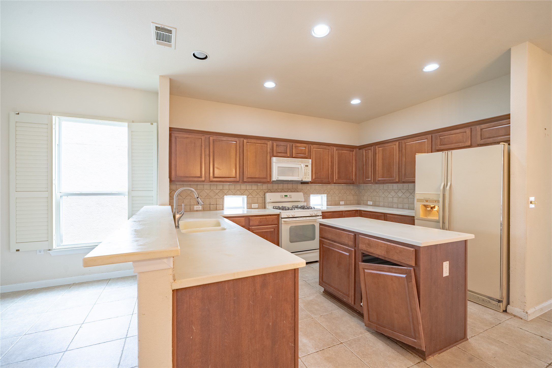 311 Deer Meadow Circle Georgetown, TX 78633 - Photo 6 of 19 a kitchen with a sink a stove a refrigerator and white cabinets