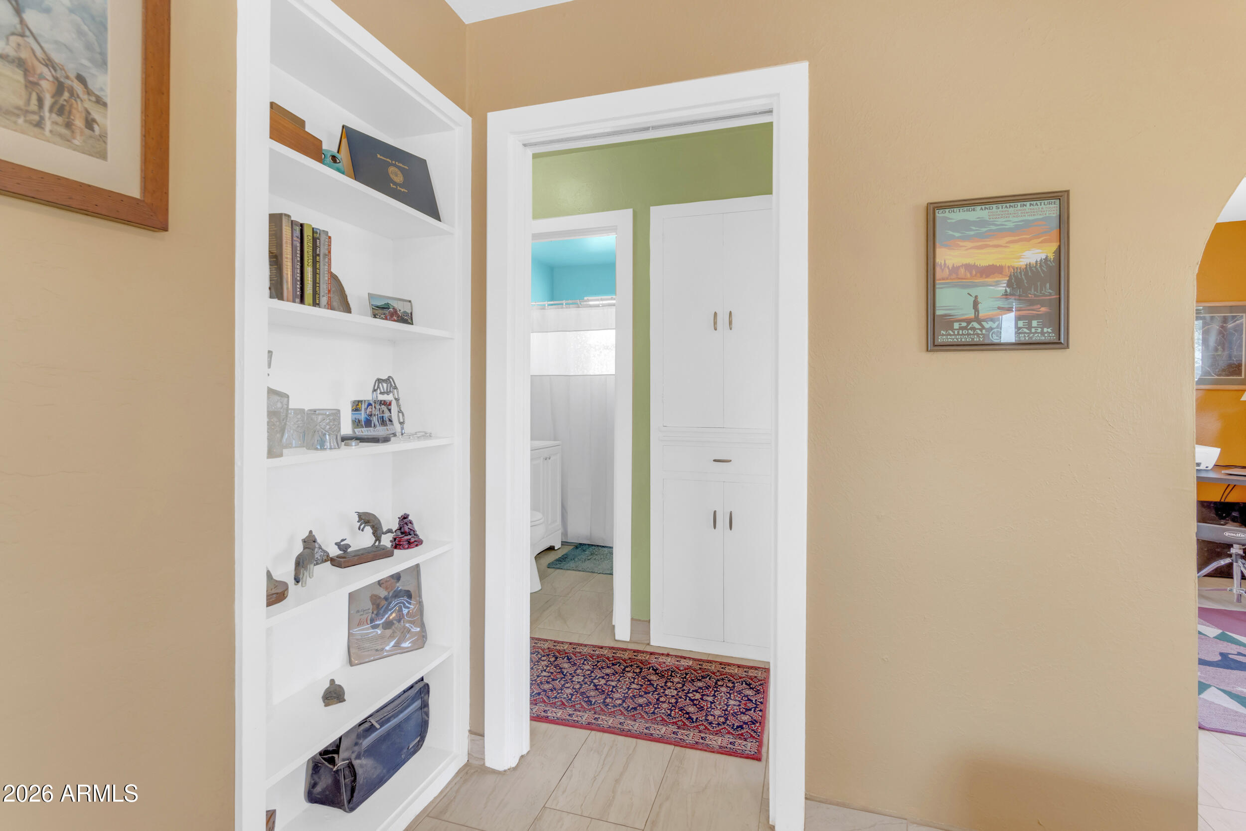 321 Solana Avenue Ajo, AZ 85321 - Photo 7 of 20 a view of a hallway with white cabinets and wooden floor