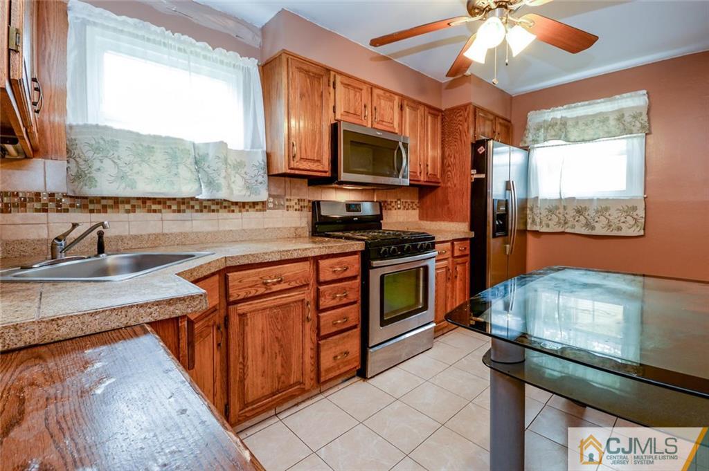 16 Stockton Road New Brunswick, NJ 08901 - Photo 7 of 25 a kitchen with stainless steel appliances a stove sink microwave and cabinets