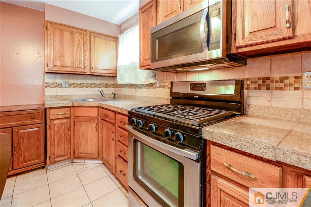 16 Stockton Road New Brunswick, NJ 08901 - Photo 8 of 25 a kitchen with stainless steel appliances granite countertop a stove microwave and sink