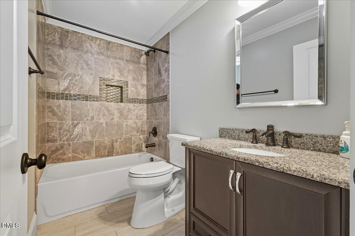 709 Winterlochen Road Raleigh, NC 27603 - Photo 21 of 52 a bathroom with a granite countertop sink mirror vanity and toilet