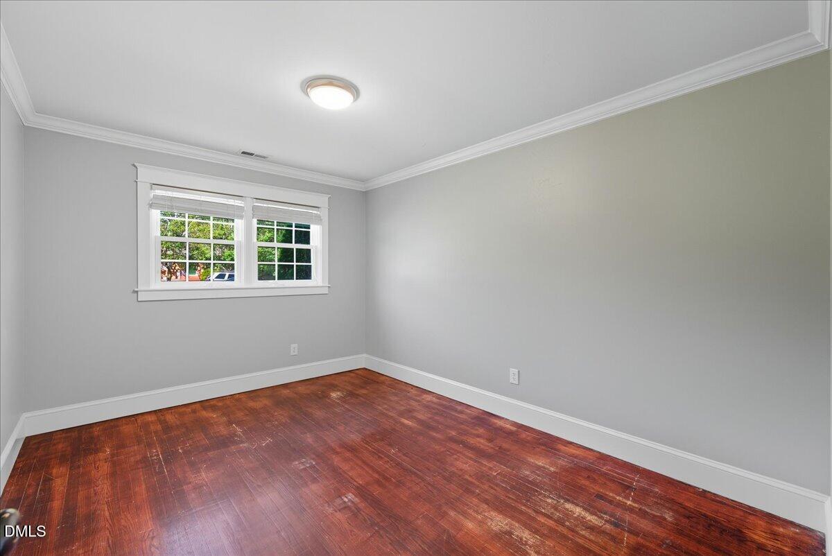 709 Winterlochen Road Raleigh, NC 27603 - Photo 22 of 52 a view of an empty room with wooden floor and a window
