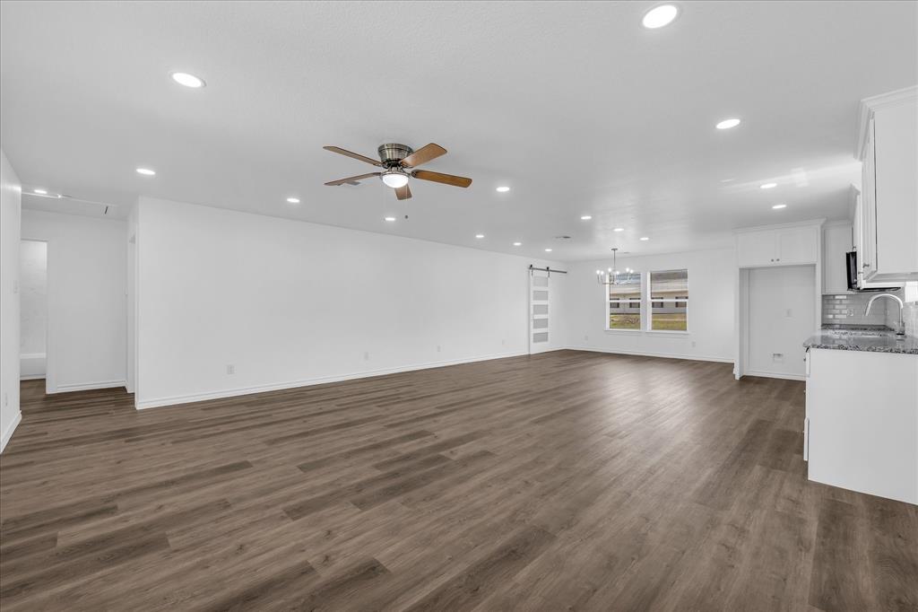 204 North Wiebusch Street Riesel, TX 76682 - Photo 6 of 33 a view of an empty room with wooden floor and a kitchen