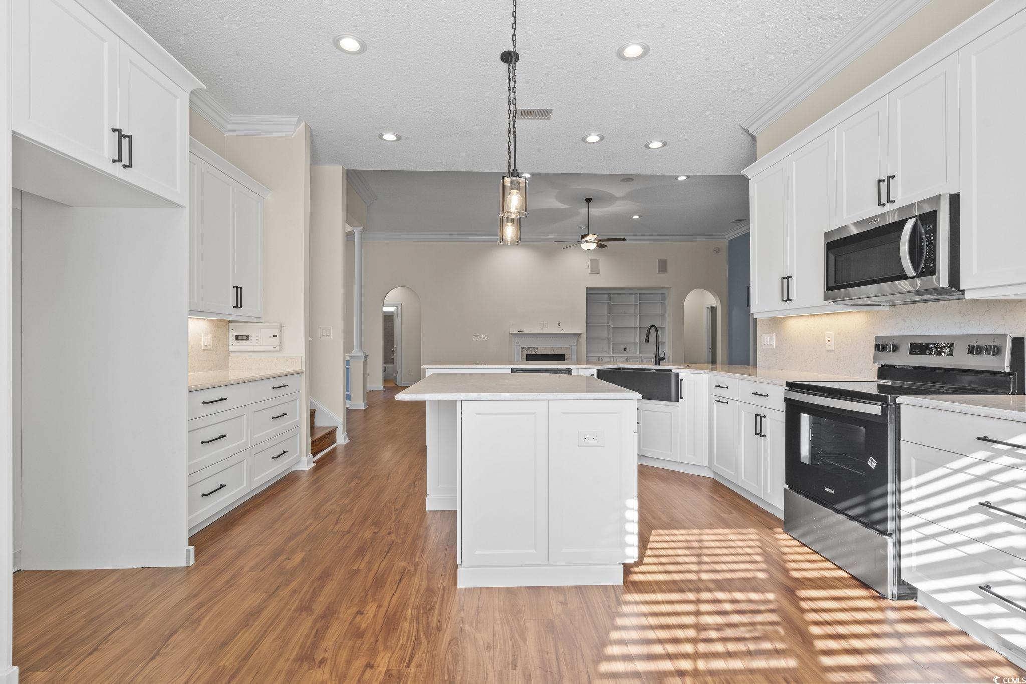 13 Grovecrest Drive Murrells Inlet, SC 29576 - Photo 13 of 40 Kitchen with ornamental molding, tasteful backsplash, arched walkways, stainless steel appliances, and pendant lighting and LVF