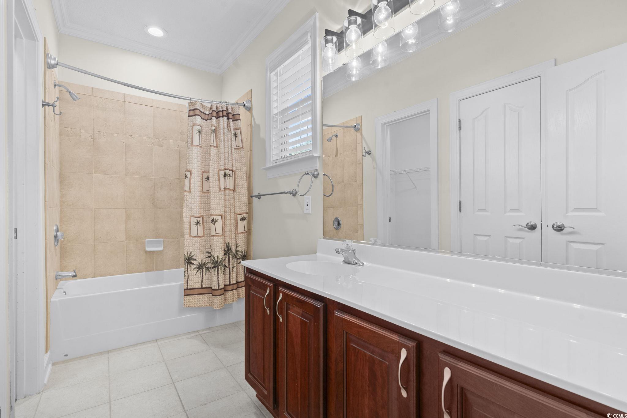 13 Grovecrest Drive Murrells Inlet, SC 29576 - Photo 23 of 40 Bathroom featuring vanity, shower / bath combo, light tile patterned flooring, crown molding, and a walk in closet