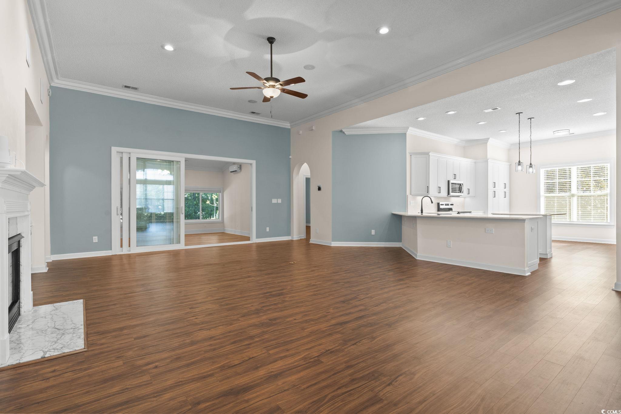 13 Grovecrest Drive Murrells Inlet, SC 29576 - Photo 8 of 40 Unfurnished living room featuring a fireplace, LVF, crown molding, ceiling fan, and recessed lighting