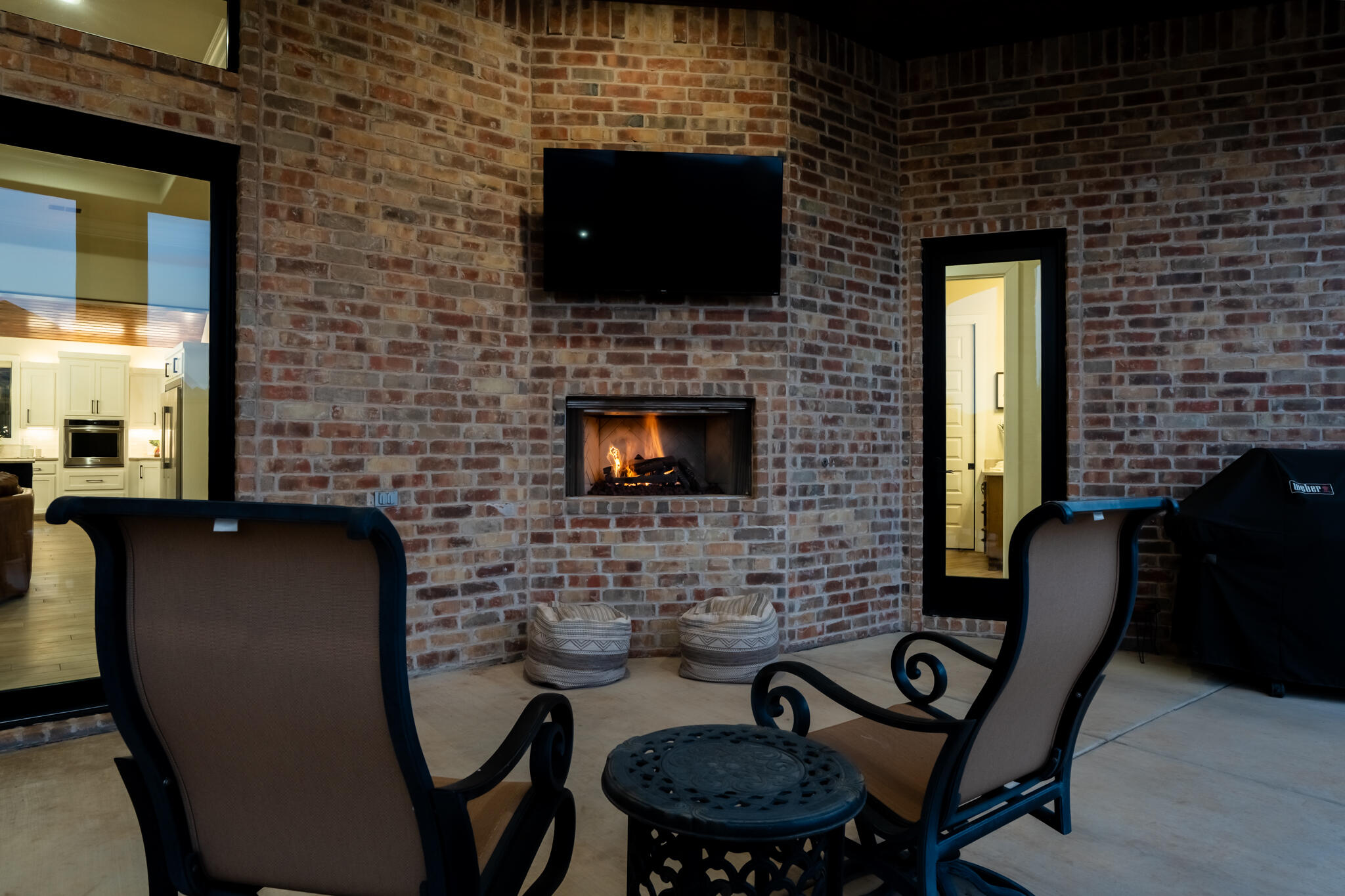 4801 118th Street Lubbock, TX 79424 - Photo 7 of 74 a brick fireplace with a chair and a flat screen tv
