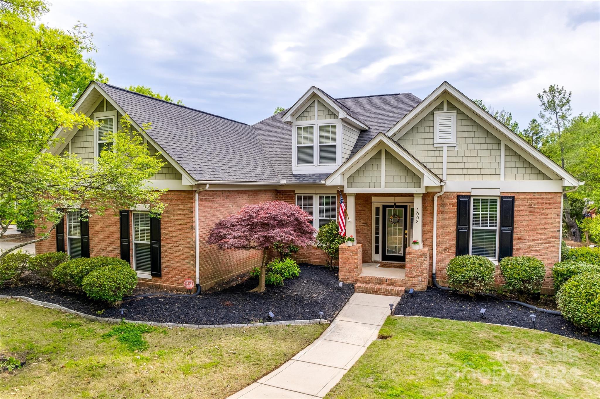 2008 Emerald Pines Drive Tega Cay, SC 29708 - Photo 33 of 48 a view of a house with a small yard plants and a large tree