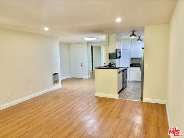 a view of a kitchen with wooden floor and electronic appliances