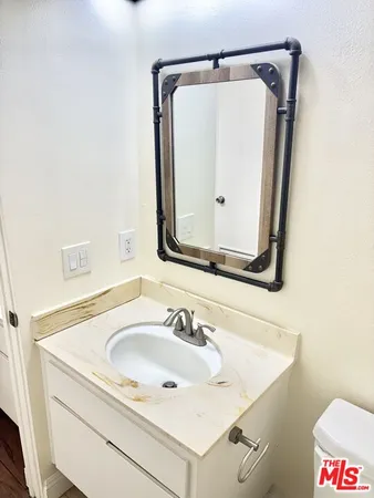 a bathroom with a sink and mirror with toilet