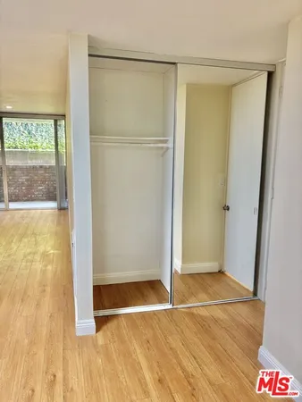 an empty room with wooden floor and a window
