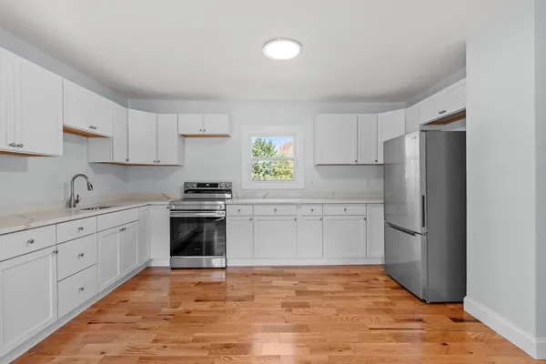 a kitchen with granite countertop white cabinets and stainless steel appliances